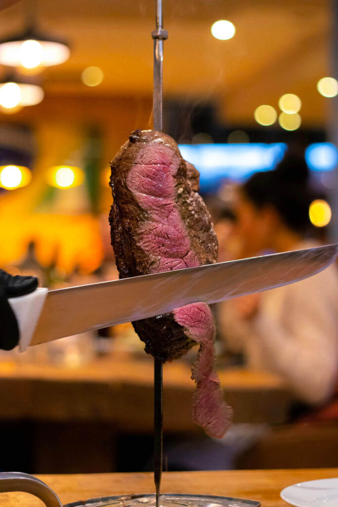 Juicy rump steak being carved from a skewer at Casa Brazilian Rodizio in York.