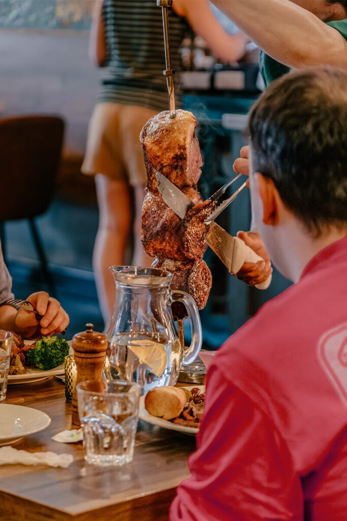 Customer pulling meat off a skewer at casa rodizio york
